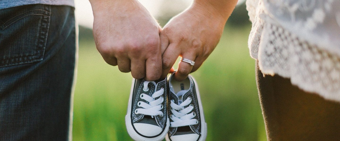 Rodiče držící botičky pro miminko
